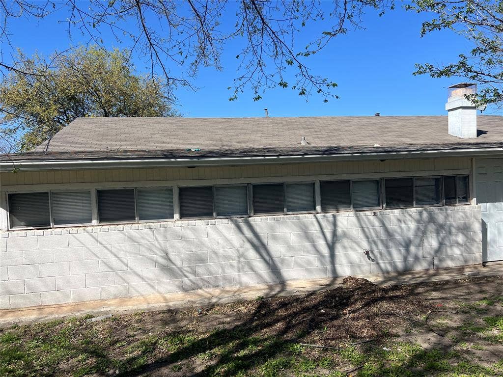 6036 Harrison Way, Watauga, TX 76148 Exterior view of a chimney and concrete block siding