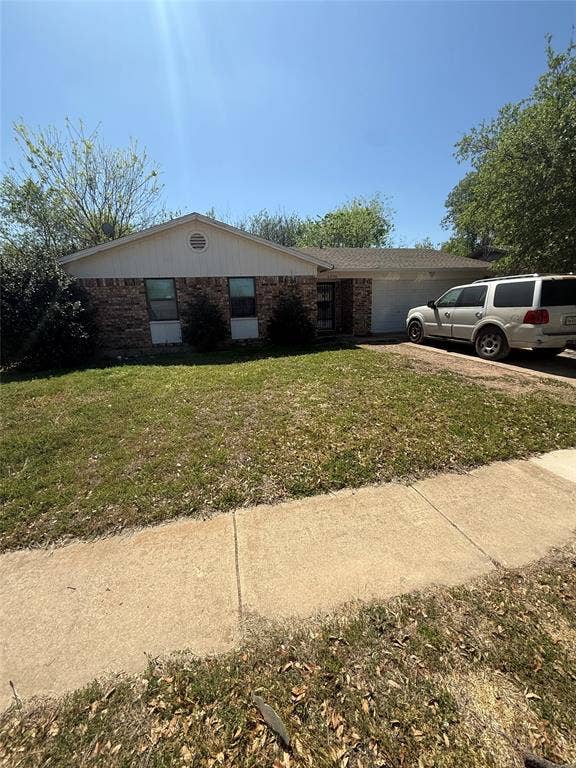 6036 Harrison Way, Watauga, TX 76148 View of front facade featuring brick siding, an attached garage, and a front yard