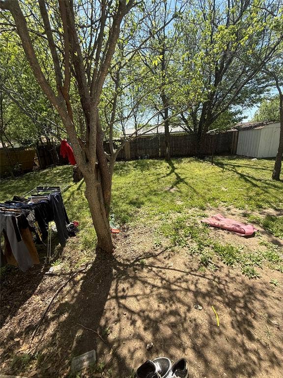 6036 Harrison Way, Watauga, TX 76148 Fenced backyard featuring a storage unit