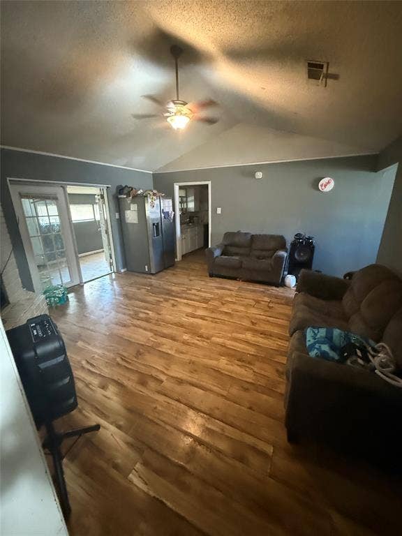 6036 Harrison Way, Watauga, TX 76148 Living area featuring wood finished floors, a ceiling fan, and a textured ceiling