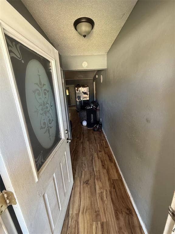 6036 Harrison Way, Watauga, TX 76148 Corridor featuring a textured ceiling and dark wood-type flooring