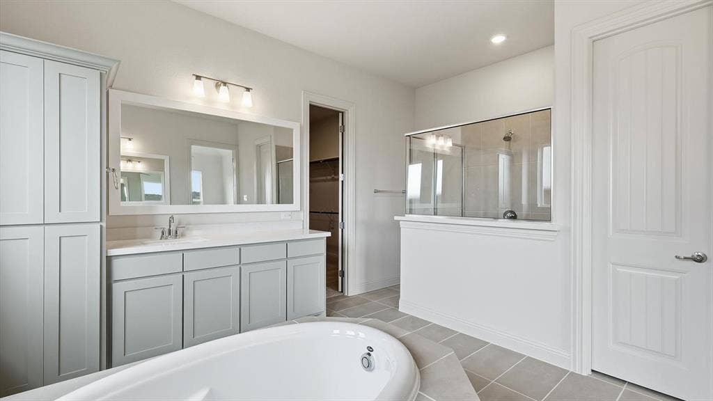 331 Fire Blade Drive, Aledo, TX 76008 Spacious bathroom featuring a built-in soaking tub, separate shower with glass enclosure, dual vanity with undermount sinks, and ample cabinetry with light gray finishes