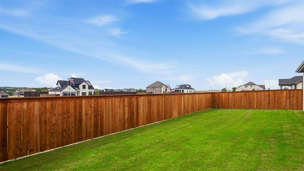 331 Fire Blade Drive, Aledo, TX 76008 Expansive backyard featuring a manicured lawn, full privacy fencing, and ample space for outdoor activities