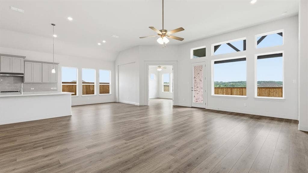 331 Fire Blade Drive, Aledo, TX 76008 Spacious open-concept living area featuring wood-finish flooring, a contemporary ceiling fan, and recessed lighting