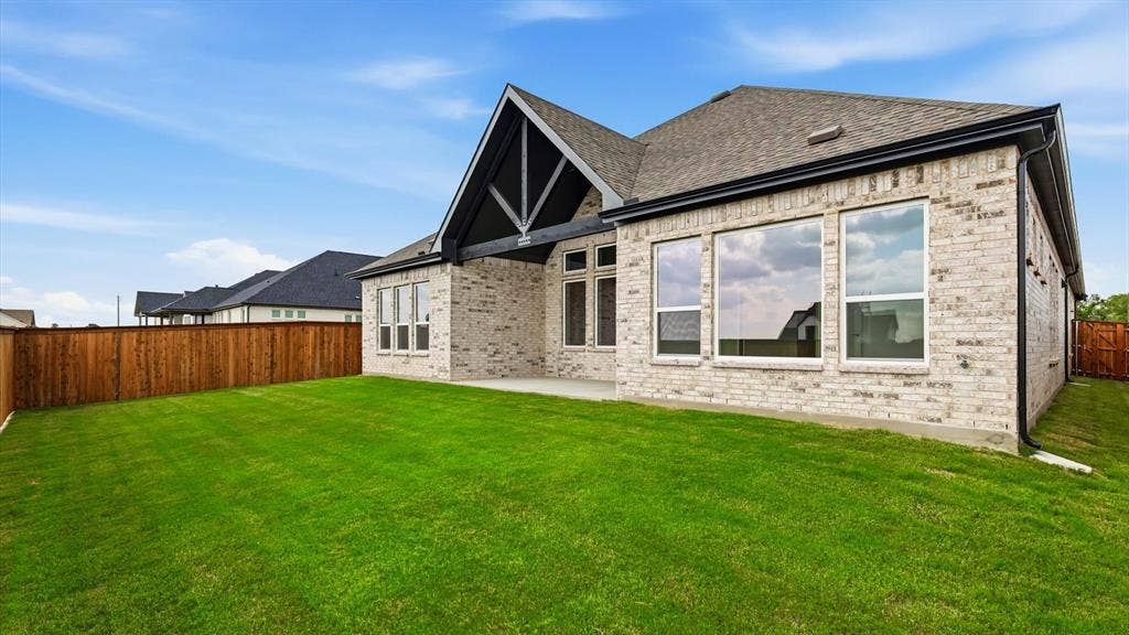 331 Fire Blade Drive, Aledo, TX 76008 Spacious backyard featuring a manicured lawn, full privacy fencing, and a covered patio area
