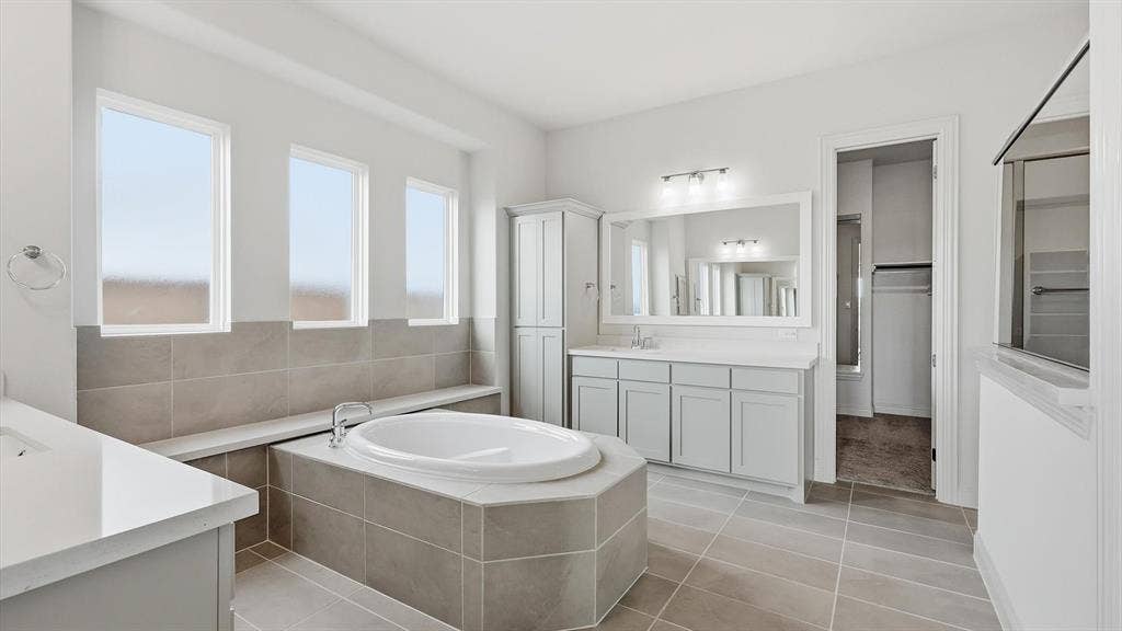 331 Fire Blade Drive, Aledo, TX 76008 Bathroom featuring a built-in soaking tub, dual vanity with light grey cabinetry, tile flooring, and a walk-in shower with a glass enclosure