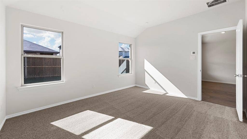 1635 Blaire Drive, Tyler, TX 75702 Empty room with vaulted ceiling and dark colored carpet