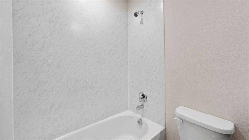 1635 Blaire Drive, Tyler, TX 75702 Bathroom with shower / bath combination and a textured wall