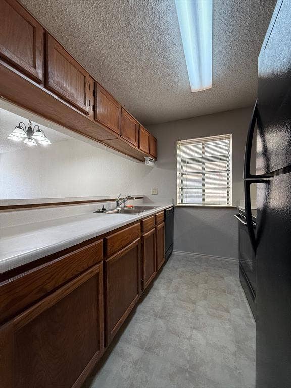 1723 Crest Grove Drive, #120B, Arlington, TX 76012 Kitchen featuring light countertops, a textured ceiling, and black appliances