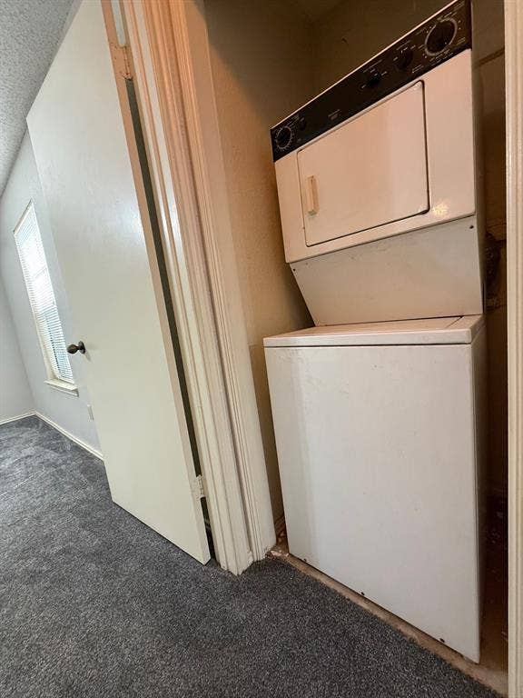 1723 Crest Grove Drive, #120B, Arlington, TX 76012 Laundry area featuring carpet floors, stacked washer and dryer, and a textured ceiling