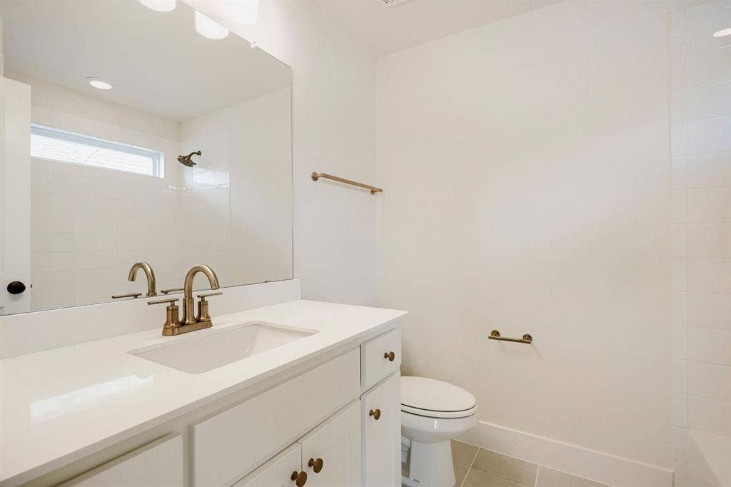 940 Heatherbrook Drive, Prosper, TX 75078 Bathroom vanity featuring a single basin, a white countertop, and brass-finish fixtures