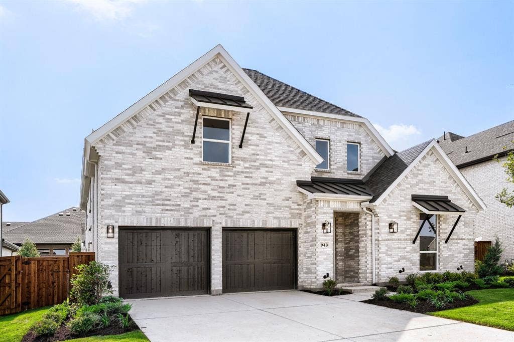 940 Heatherbrook Drive, Prosper, TX 75078 Contemporary two-story residence featuring a light-colored brick facade, dark wood-finish garage doors, and a concrete driveway