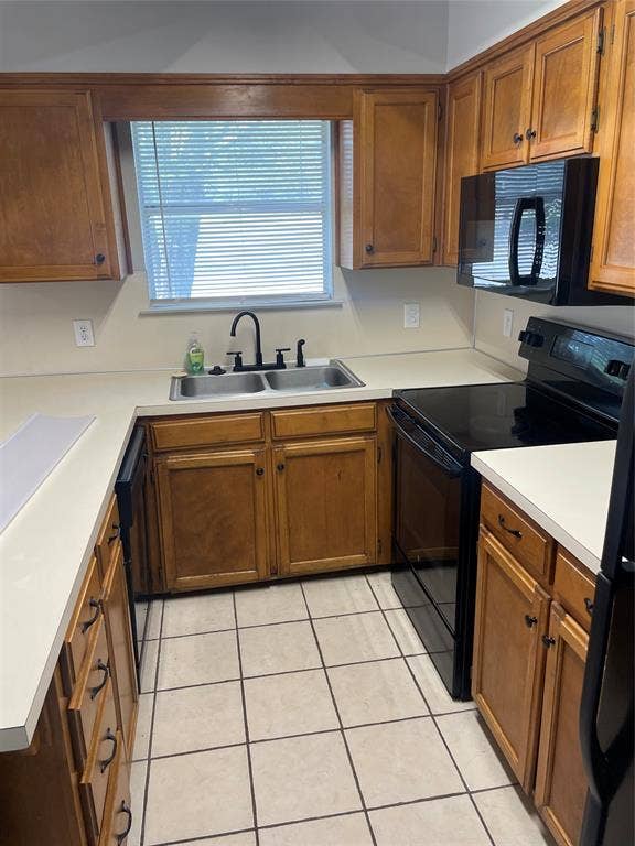 3441 Pewitt Drive, #43, Waco, TX 76706 Kitchen featuring black appliances, wood finish cabinetry, light countertops, and light tile patterned floors