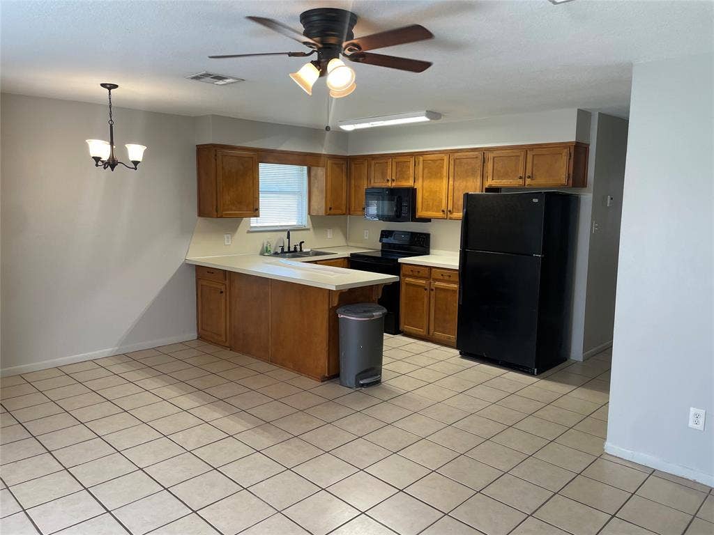 3441 Pewitt Drive, #43, Waco, TX 76706 Kitchen featuring wood finish cabinetry, light countertops, black appliances, a peninsula, and ceiling fan