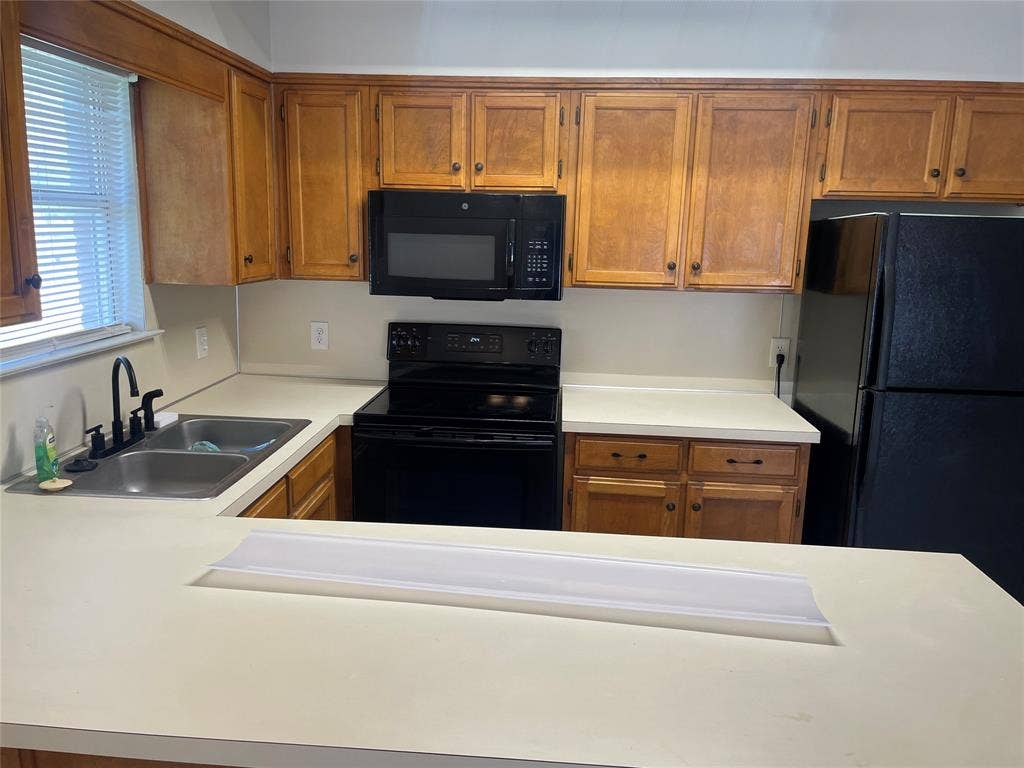 3441 Pewitt Drive, #43, Waco, TX 76706 Kitchen with black appliances, wood finish cabinetry, and light countertops