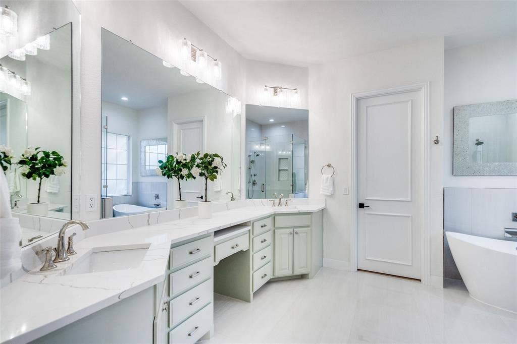 Spa-like primary bathroom with oversized vanity and makeup desk.