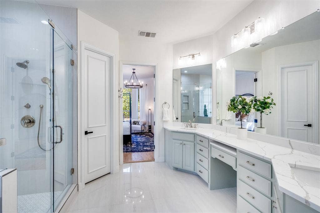 Glass enclosure shower with bench.