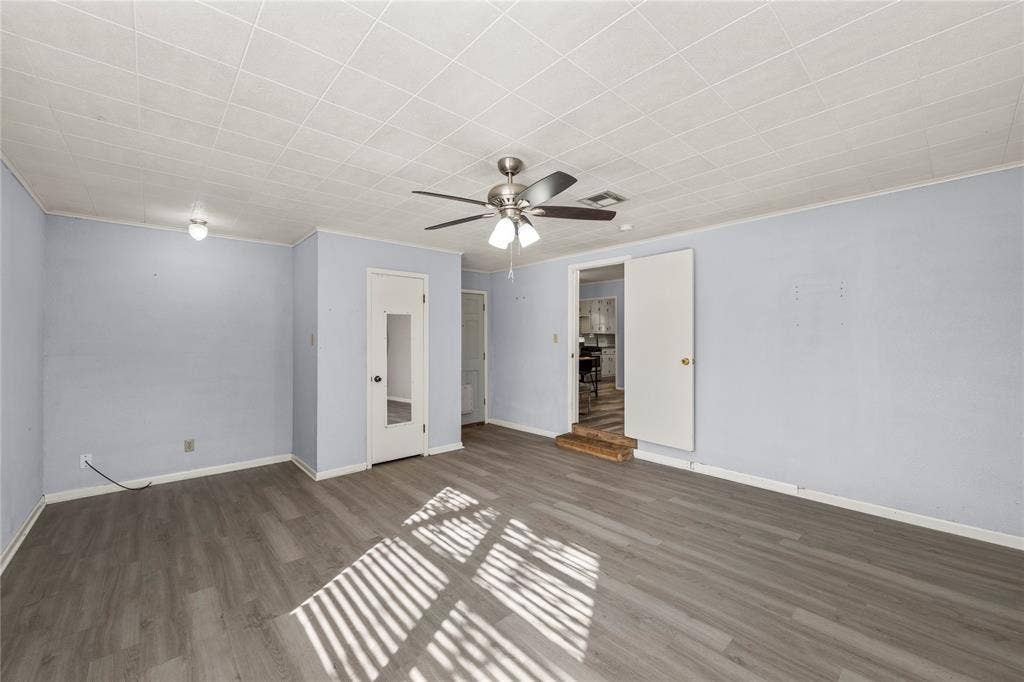 901 N Main Street, West, TX 76691 Unfurnished bedroom with dark wood-type flooring, ornamental molding, and a ceiling fan