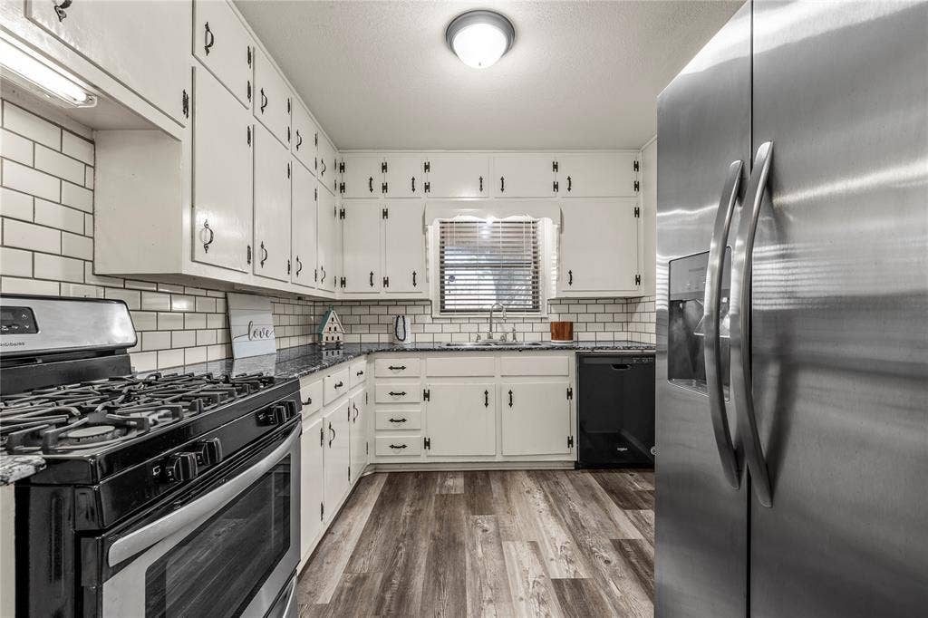 901 N Main Street, West, TX 76691 Kitchen featuring stainless steel appliances, dark stone counters, dark wood finished floors, and white cabinets