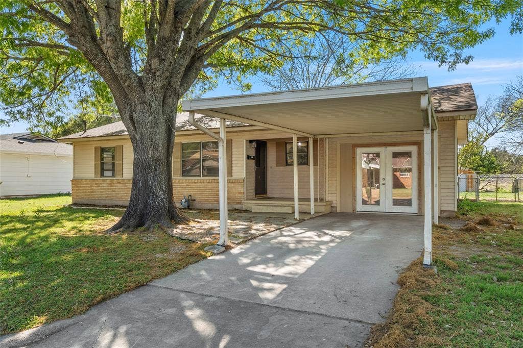 901 N Main Street, West, TX 76691 View of front facade featuring a carport, driveway, french doors, and a front lawn