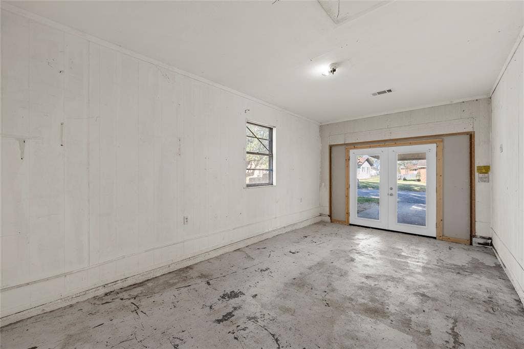 901 N Main Street, West, TX 76691 Spare room with french doors, concrete flooring, and wooden walls