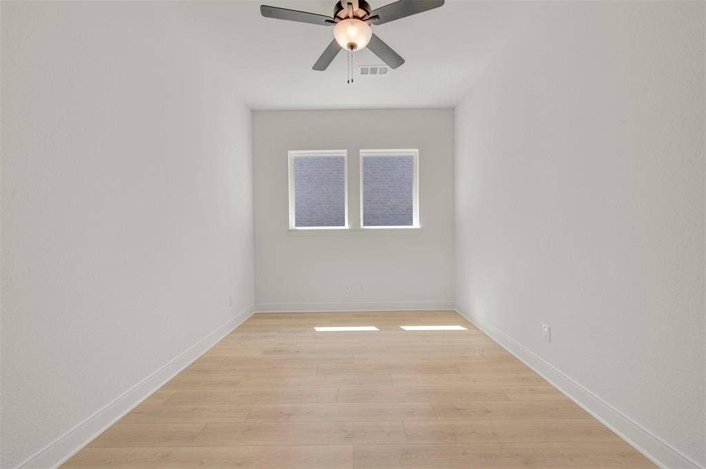 1709 Drover Street, Northlake, TX 76247 Room featuring wood-finish flooring, two windows with blinds, a ceiling fan with integrated lighting, and white baseboards