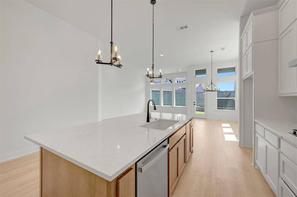 1709 Drover Street, Northlake, TX 76247 Kitchen island featuring a white countertop, undermount sink, and wood-finish cabinetry