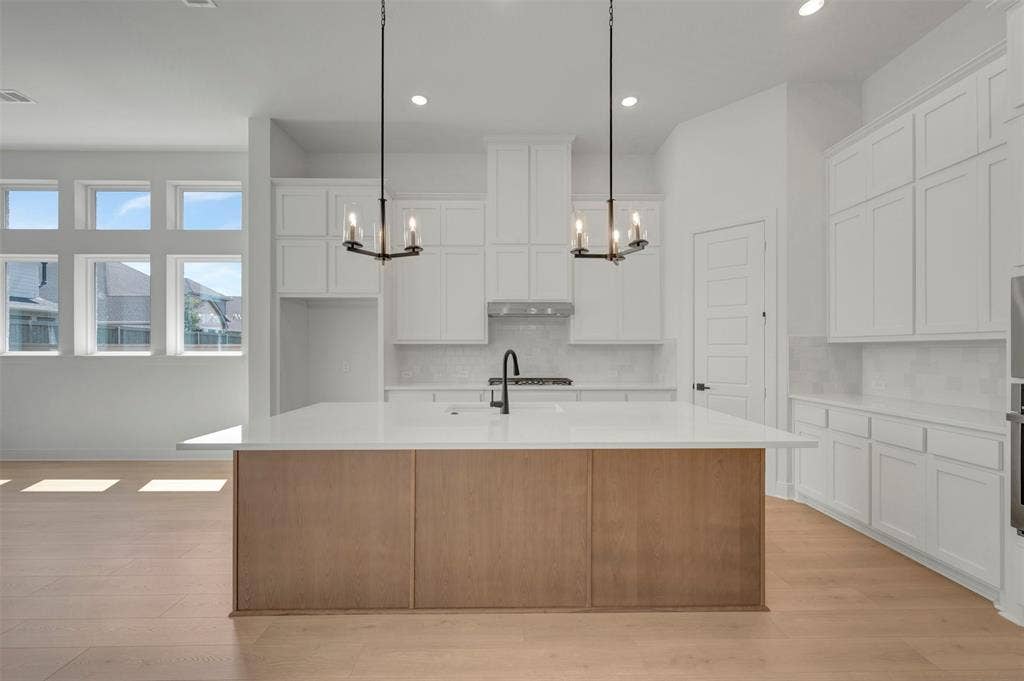 1709 Drover Street, Northlake, TX 76247 Open-concept kitchen featuring a large central island with a wood-finish base, white countertop, and contemporary black faucet