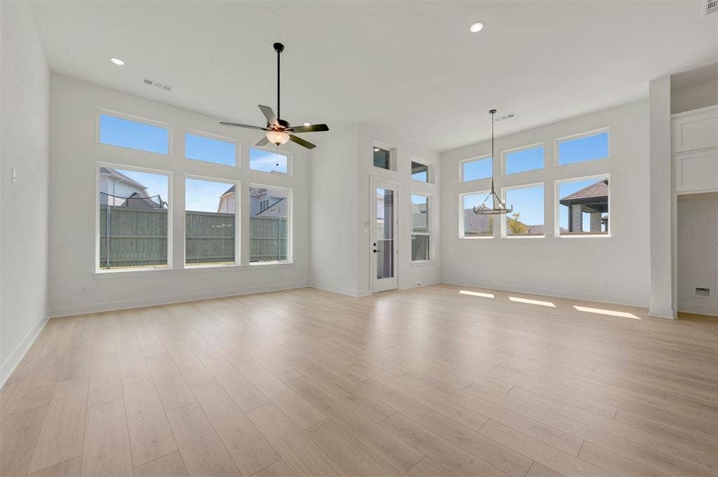 1709 Drover Street, Northlake, TX 76247 Spacious room featuring high ceilings, light wood-finish flooring, abundant natural light from multiple large windows, and recessed lighting