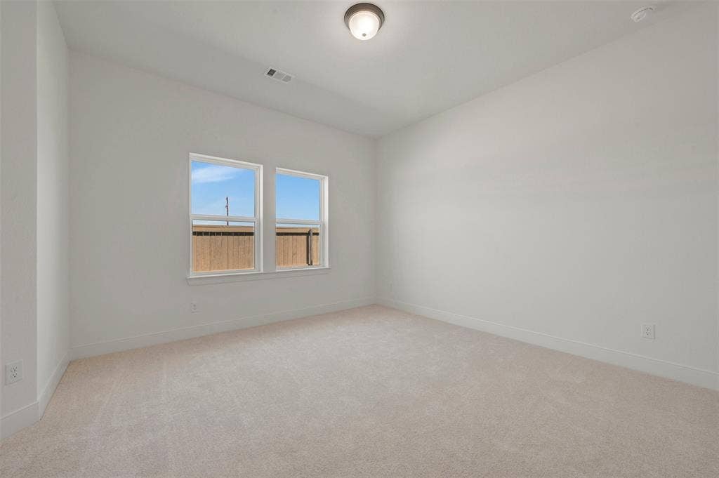 1709 Drover Street, Northlake, TX 76247 Room featuring light-toned carpet flooring, two rectangular windows, and a flush-mount ceiling light fixture