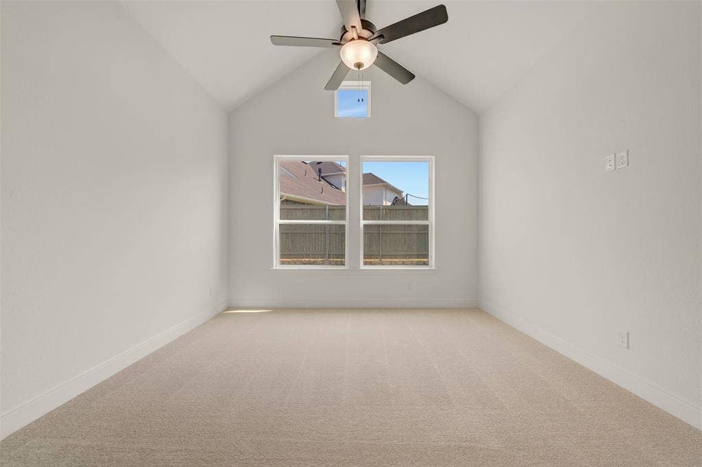 1709 Drover Street, Northlake, TX 76247 Room featuring a vaulted ceiling with a ceiling fan, two windows, and light-toned carpeting
