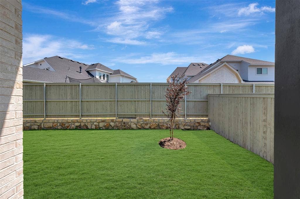 1709 Drover Street, Northlake, TX 76247 Expansive backyard featuring a manicured lawn, a young tree, and a full privacy fence
