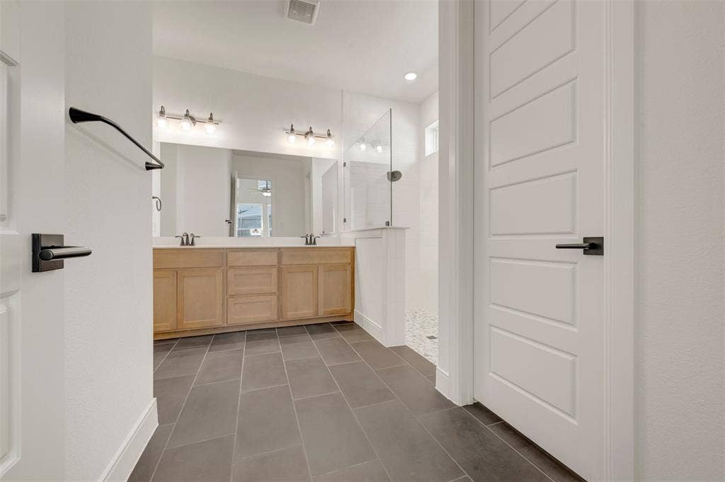 1709 Drover Street, Northlake, TX 76247 Spacious bathroom featuring a dual vanity with light wood cabinetry, a large frameless mirror, and modern light fixtures