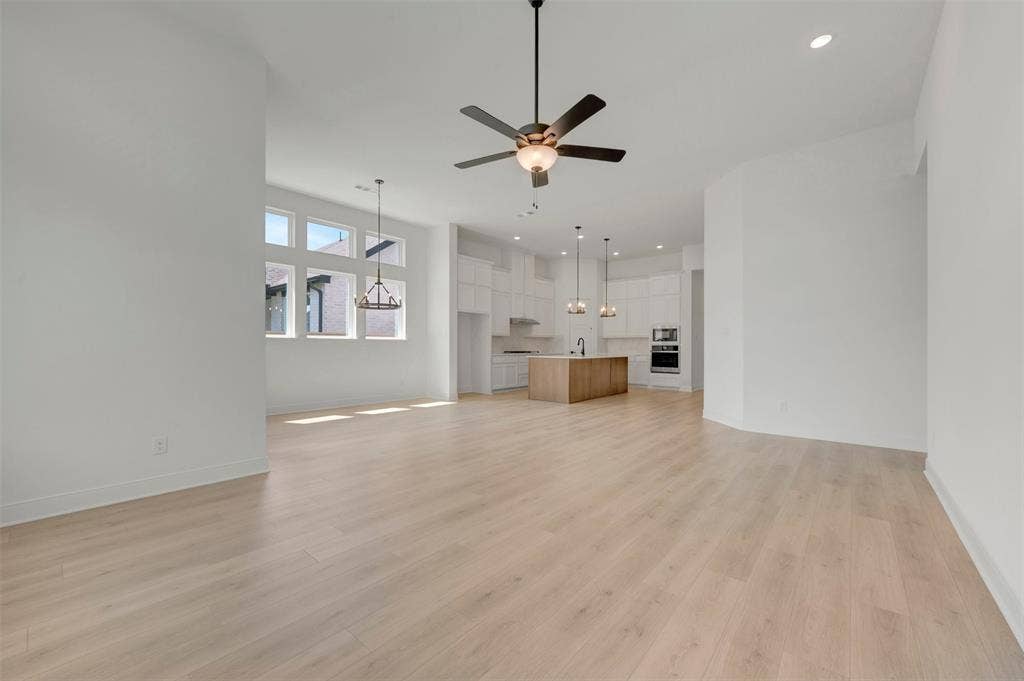 1709 Drover Street, Northlake, TX 76247 Expansive open-concept living area featuring light wood-finish flooring, a contemporary ceiling fan, and recessed lighting