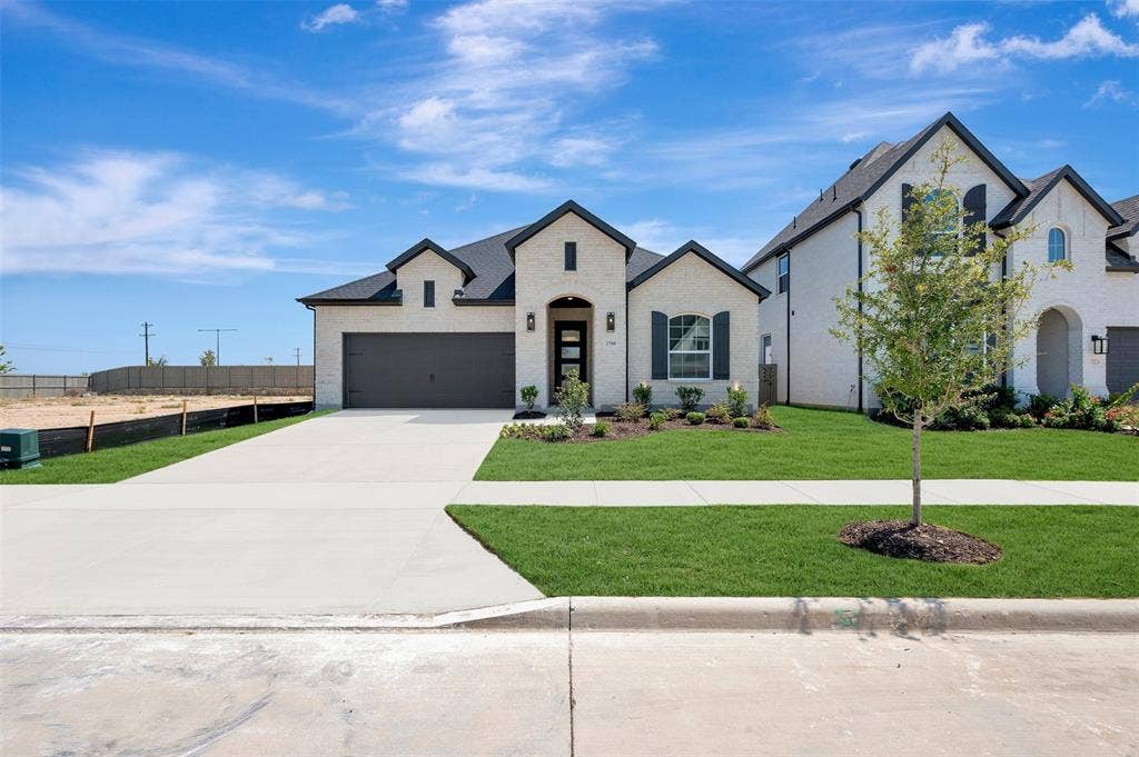 1709 Drover Street, Northlake, TX 76247 Contemporary residence featuring a light-colored brick facade, dark roofing, and a two-car garage