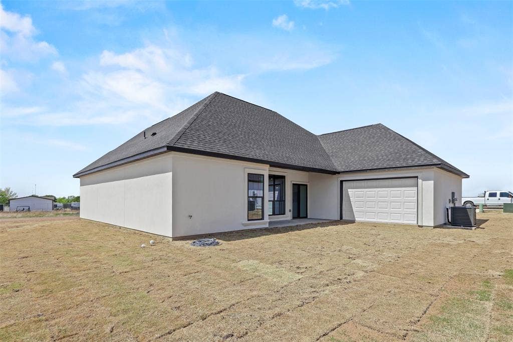 271 Victory Drive, Mabank, TX 75147 Rear view of property with roof with shingles, an attached garage, a patio, and a yard