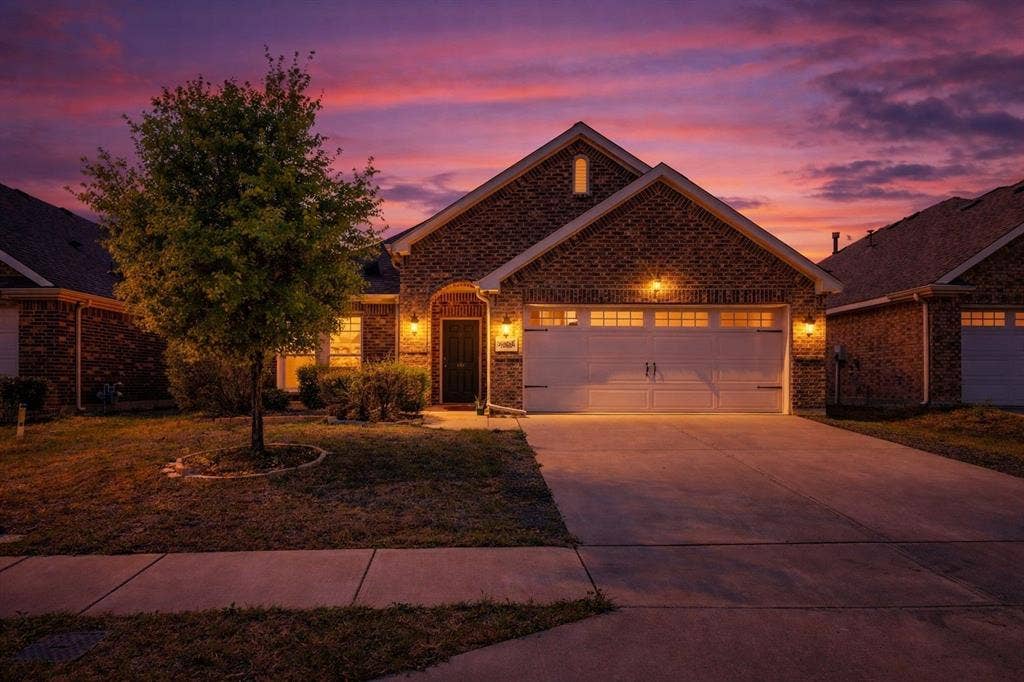 2609 Centurion Road, Glenn Heights, TX 75154 Traditional-style home with an attached garage, driveway, brick siding, and a front lawn