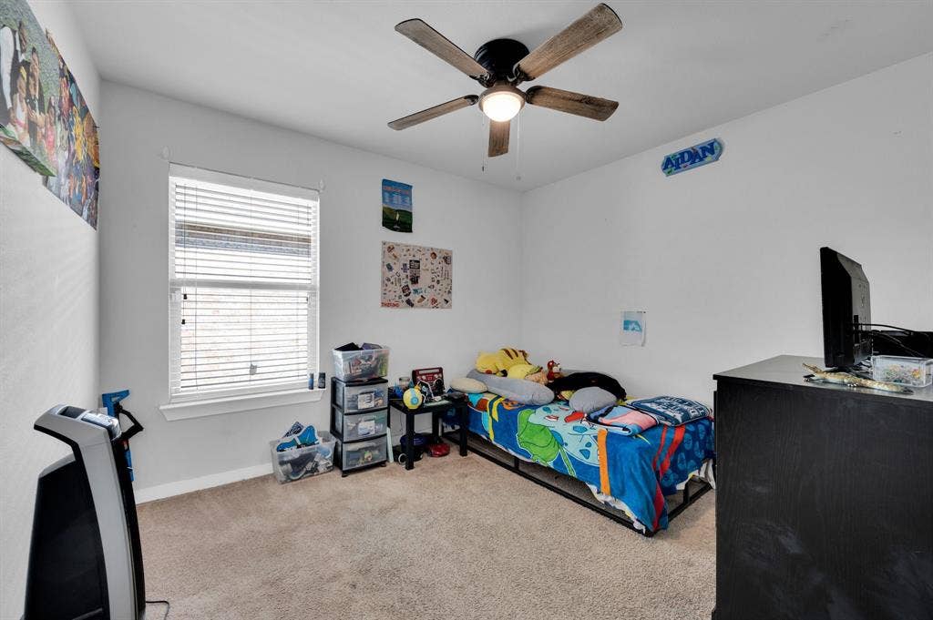 2609 Centurion Road, Glenn Heights, TX 75154 Bedroom with light colored carpet and ceiling fan
