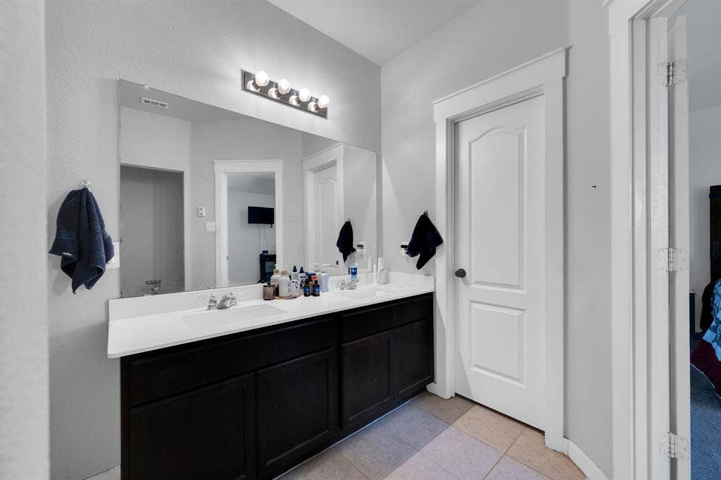 2609 Centurion Road, Glenn Heights, TX 75154 Bathroom with double vanity and light tile patterned flooring