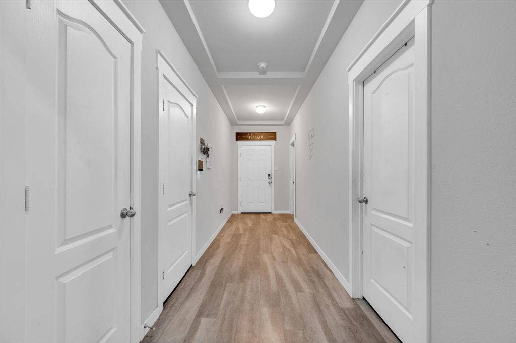 2609 Centurion Road, Glenn Heights, TX 75154 Hallway with light wood-style flooring and a raised ceiling