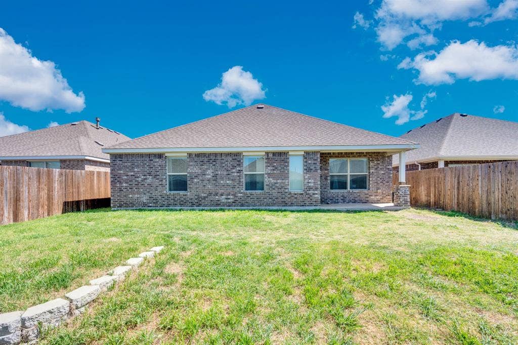2609 Centurion Road, Glenn Heights, TX 75154 Rear view of property featuring a fenced backyard, brick siding, a patio, and a shingled roof