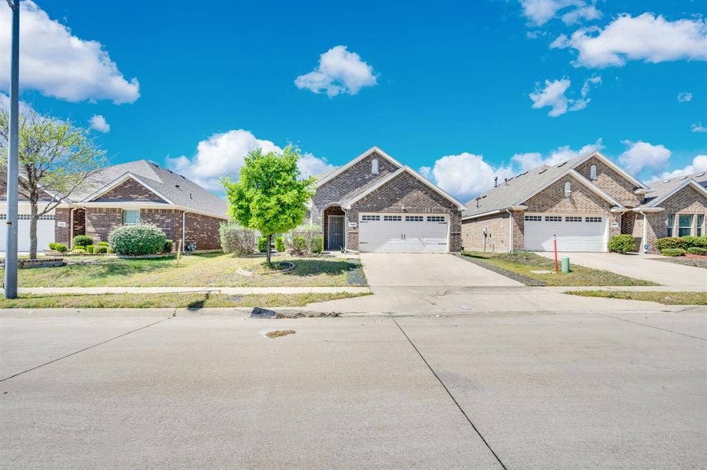 2609 Centurion Road, Glenn Heights, TX 75154 Ranch-style home with driveway, a garage, brick siding, a residential view, and a front lawn