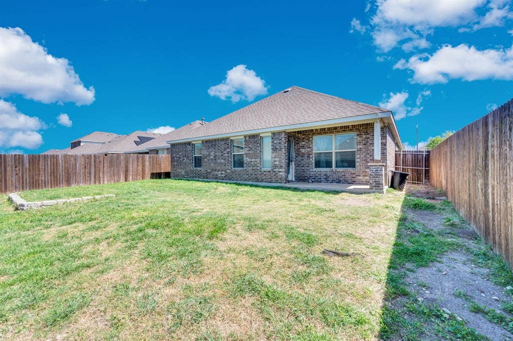 2609 Centurion Road, Glenn Heights, TX 75154 Back of house with a patio area, brick siding, a fenced backyard, and roof with shingles