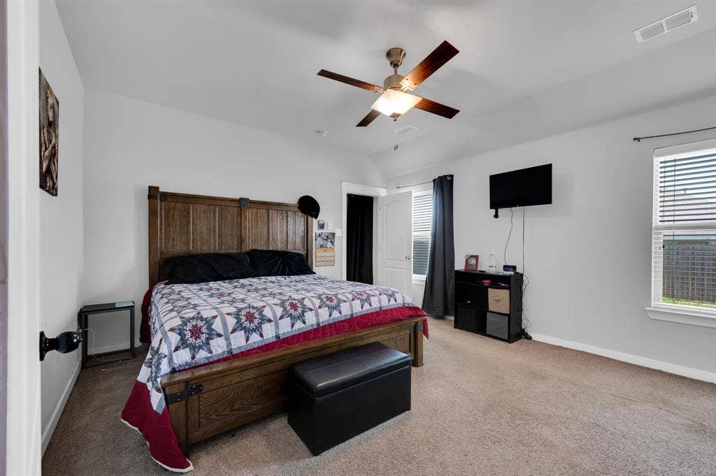 2609 Centurion Road, Glenn Heights, TX 75154 Bedroom with light colored carpet, a ceiling fan, multiple windows, and lofted ceiling