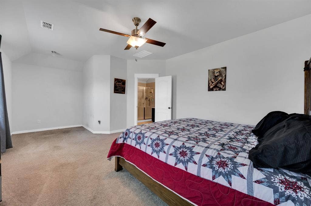 2609 Centurion Road, Glenn Heights, TX 75154 Bedroom featuring light carpet, ceiling fan, and ensuite bath