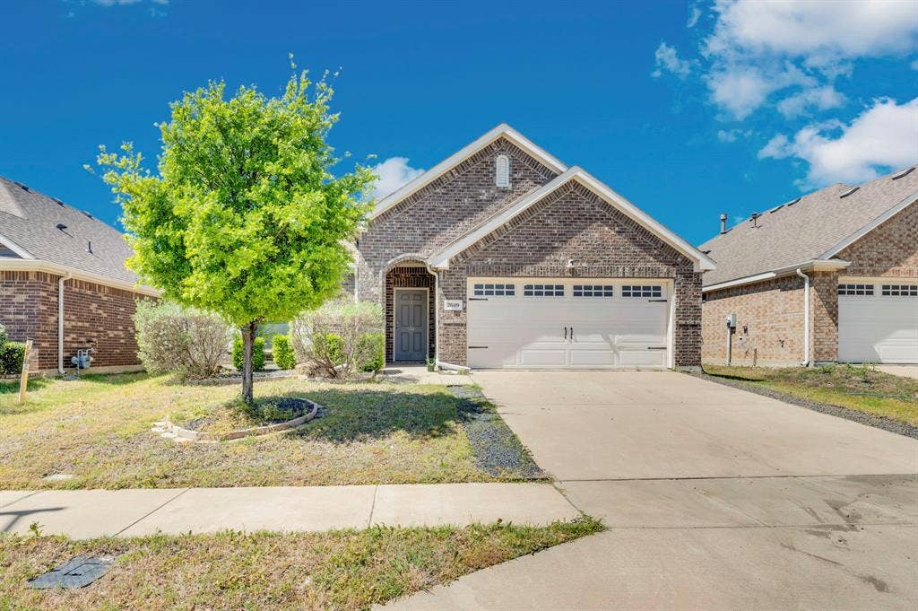 2609 Centurion Road, Glenn Heights, TX 75154 View of front of home featuring an attached garage, brick siding, and concrete driveway