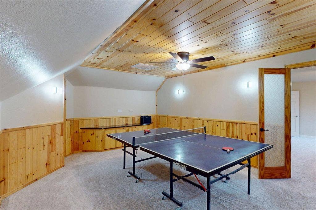 349 Creekside Trail, Argyle, TX 76226 Recreation room with wood walls, wainscoting, vaulted ceiling, a ceiling fan, and light colored carpet