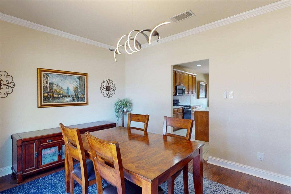 349 Creekside Trail, Argyle, TX 76226 Dining space with dark wood-type flooring, crown molding, and suspended lighting