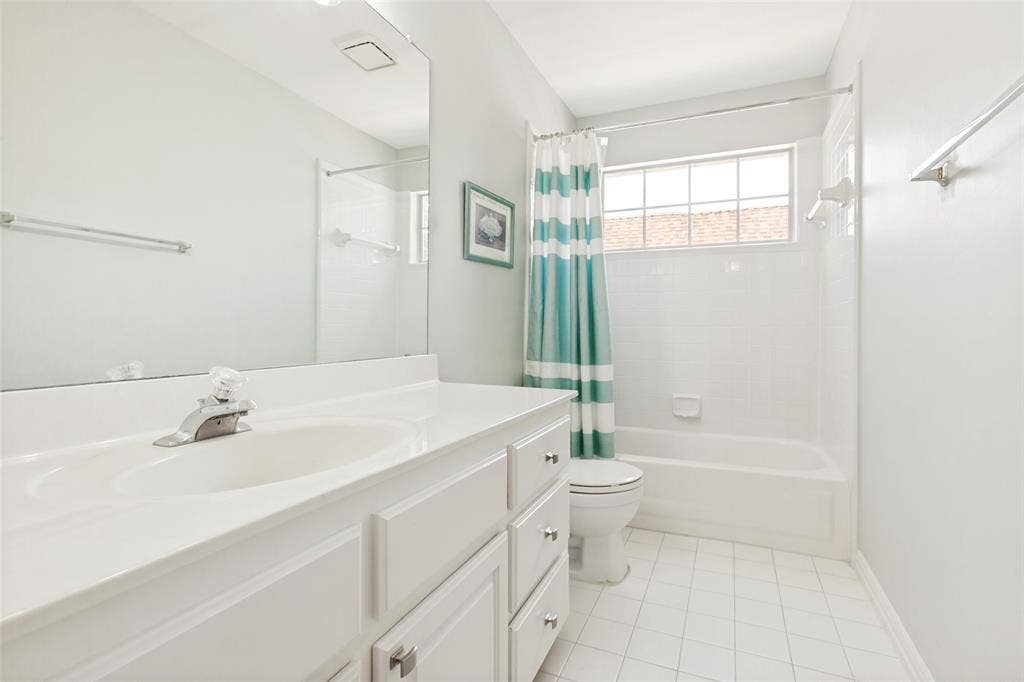 2632 Barrington Drive, Plano, TX 75093 Separate bathroom featuring a white vanity with integrated sink, a large wall-mounted mirror, a bathtub with white subway tile surround, a window, white tile flooring and updated light fixture