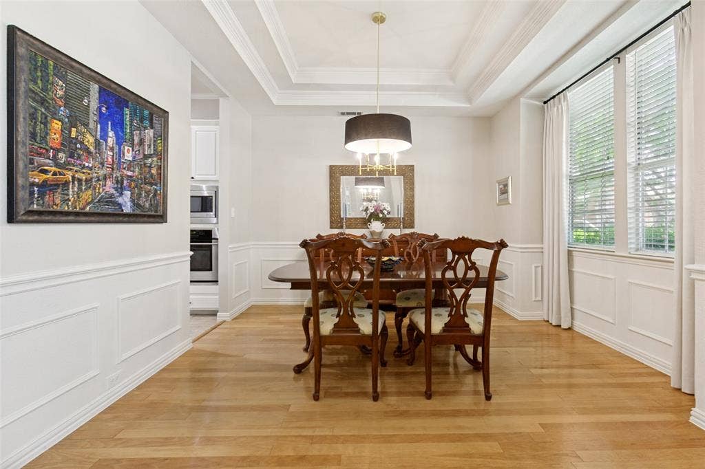 2632 Barrington Drive, Plano, TX 75093 Dining area featuring wood-finish flooring, wainscoting, and a coffered ceiling